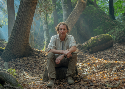 Hervé Covès expliquant la résilience écologique de la forêt de la Massane, avec un paysage dense de hêtres anciens et une végétation variée en arrière-plan